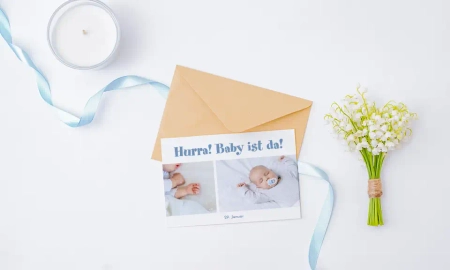 Geburtskarte mit blauem Schriftzug "Hurra!" Baby ist da!" und Bild des kleinen Babys