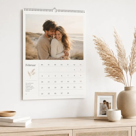 Fotokalender mit persönlicher Gestaltungsvorlage an einer hellen Wand über einer Holzkommode mit dekorativen Wohnaccessoires