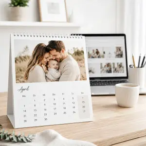 Tischkalender mit Familienfoto auf einem hellen Schreibtisch im Homeoffice Umfeld