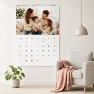 Fotokalender mit Familienfoto an einer Wohnzimmerwand in heller Wohnumgebung