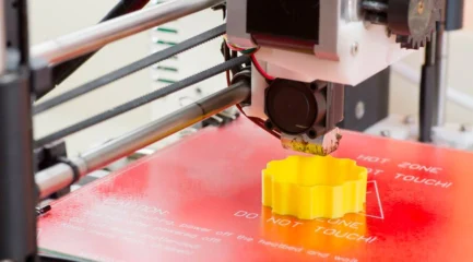 Ein 3D-Drucker druckt ein Objekt aus heißem Filament. Der 3D Drucker extrudiert das Material präzise Schicht für Schicht.