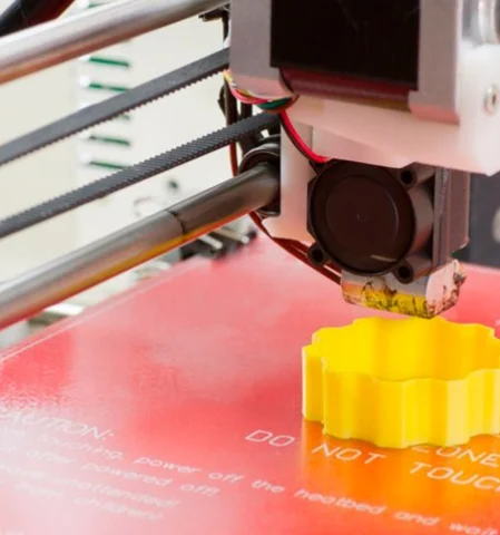 Ein 3D-Drucker druckt ein Objekt aus heißem Filament. Der 3D Drucker extrudiert das Material präzise Schicht für Schicht.