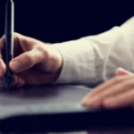 Logo erstellen auf Tablet: Männerhand hält Stift und arbeitet an Symbolen für Logos und Design.